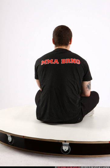 Man Adult Athletic White Fighting with submachine gun Sitting poses Sportswear