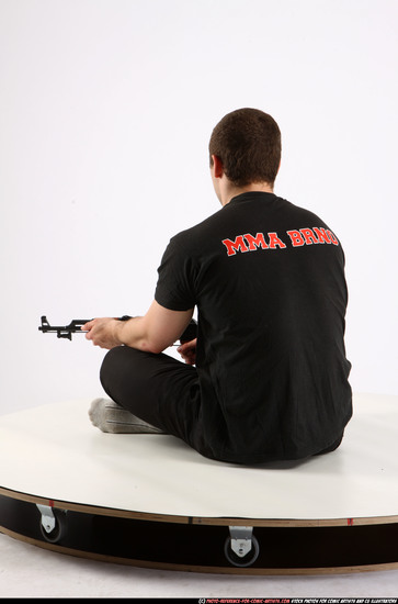 Man Adult Athletic White Fighting with submachine gun Sitting poses Sportswear