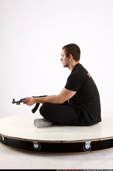 Man Adult Athletic White Fighting with submachine gun Sitting poses Sportswear