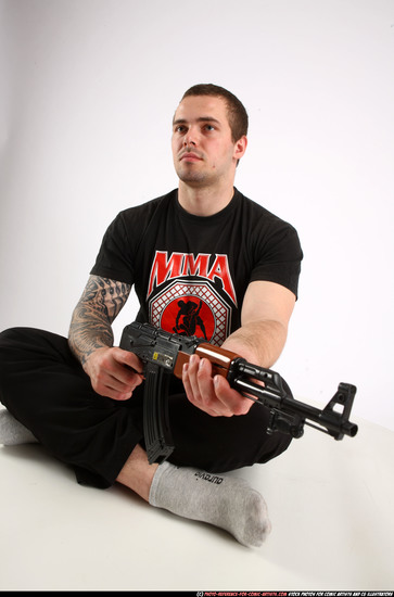 Man Adult Athletic White Fighting with submachine gun Sitting poses Sportswear