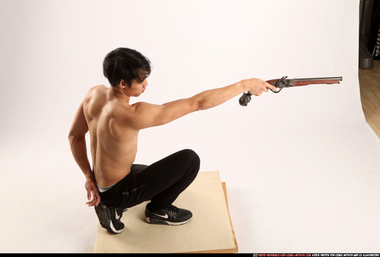 Man Young Athletic Fighting with gun Kneeling poses Pants Asian