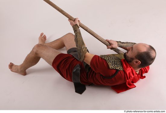 Man Adult Average White Fighting with spear Laying poses Casual