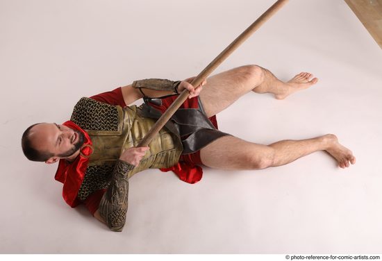 Man Adult Average White Fighting with spear Laying poses Casual