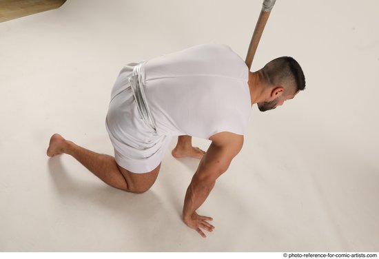 Man Adult Muscular Fighting with spear Kneeling poses Coat Latino