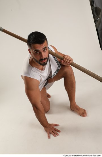 Man Adult Muscular Fighting with spear Kneeling poses Coat Latino