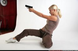 Woman Adult Athletic White Fighting with gun Kneeling poses Sportswear