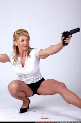 Woman Adult Muscular White Fighting with gun Kneeling poses Sportswear