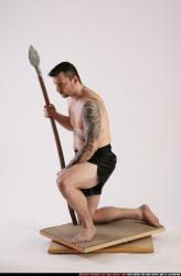 Man Adult Athletic White Fighting with spear Kneeling poses Sportswear