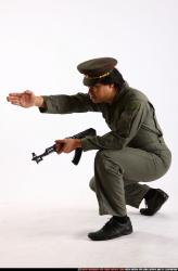 Man Adult Average Fighting with submachine gun Kneeling poses Army Asian