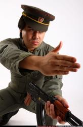 Man Adult Average Fighting with submachine gun Kneeling poses Army Asian